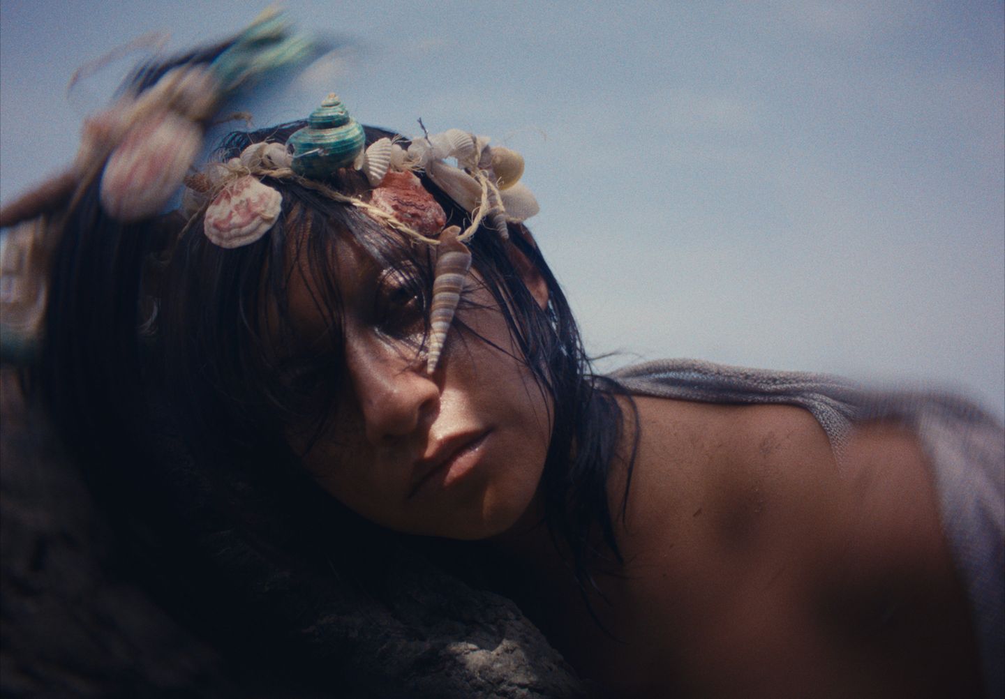 Retrato con conchas y caracoles enredados en el pelo, movido por el viento.