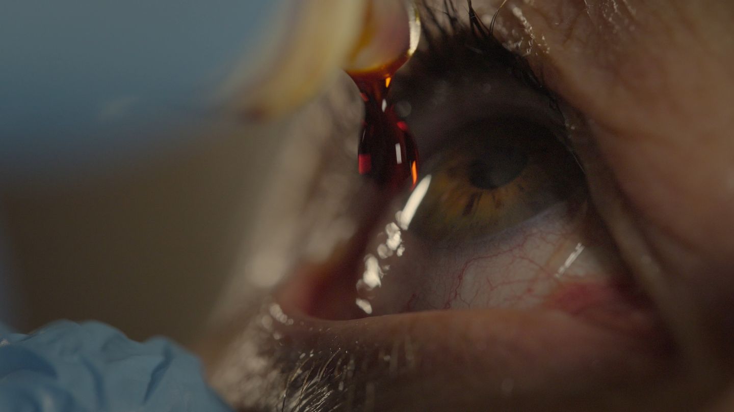 Primerísimo plano de un ojo; destellos de color sobre la córnea.
