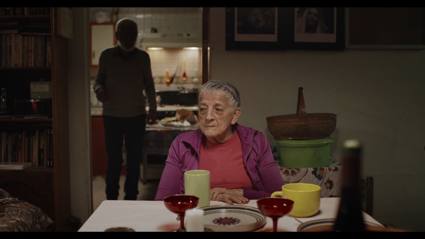 La pareja desayuna frente a frente en la mesa de la cocina.